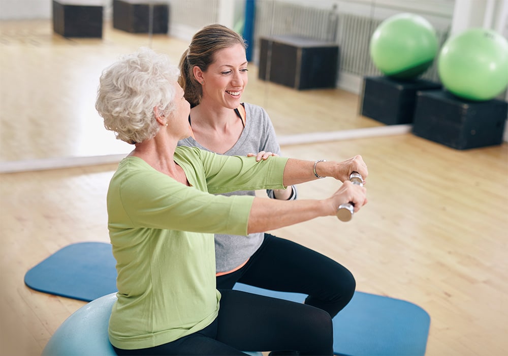 Rehab staff assisting a patient with exercises.