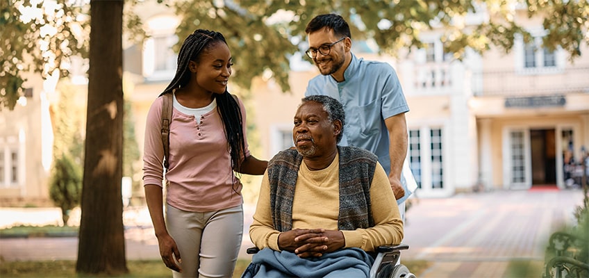 A senior man visiting with his family outside